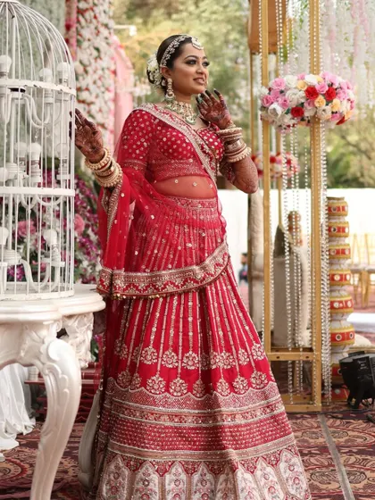 The grandeur of a full bridal look. The rich red of her lehenga is complemented by a makeup palette that is warm, inviting, and absolutely timeless.