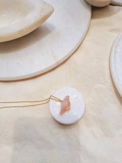 A simple, elegant shot of the Peach Moonstone Dove pendant.