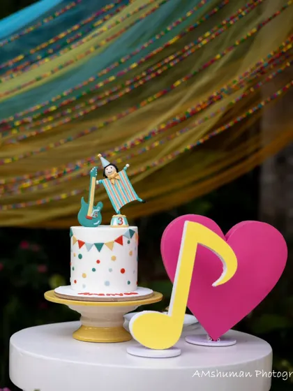 A whimsical cake and dessert display from the music-themed party, featuring a colorful cake, a heart cutout, and a musical note prop.