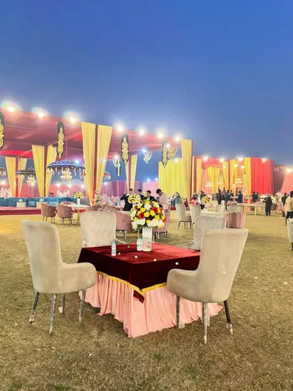 A simple yet elegant table setting on the lawn, with the grandly decorated main tent in the background.