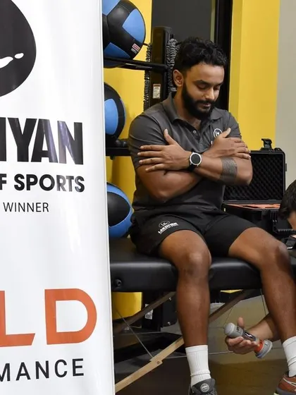 A coach uses a handheld dynamometer to test an athlete's lower limb strength. This precise measurement helps in tracking progress and ensuring symmetrical strength development.