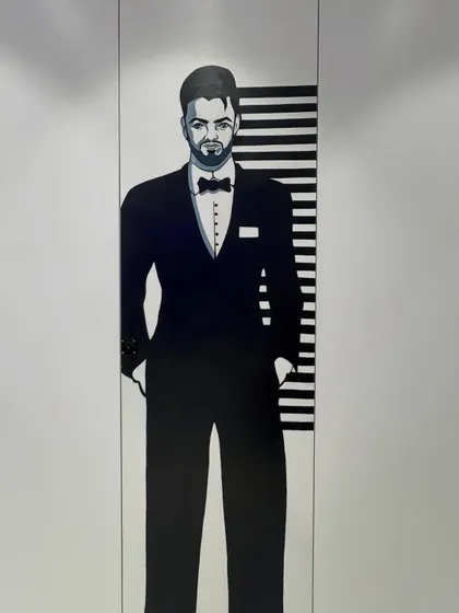 A close-up of the gents' washroom mural, a stylish and modern portrait that adds character to an often-overlooked space.