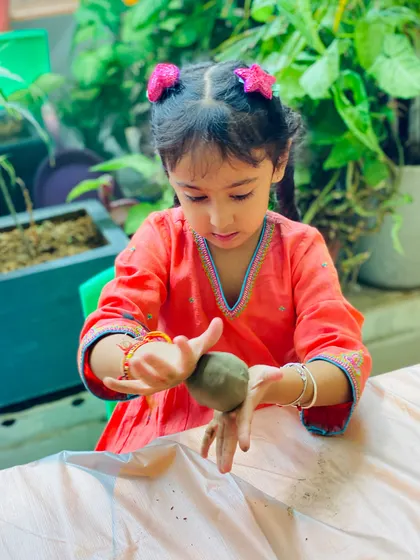 This young artist is fully immersed in her craft. The tactile nature of clay is excellent for sensory development and creative expression.
