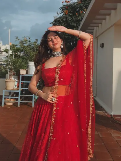 A playful shot of the client enjoying the sun in her red lehenga.