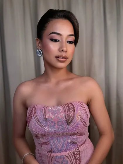 A soft, romantic look perfect for a cocktail evening. The pixie haircut is styled elegantly to the side, paired with a pink monochromatic makeup look that is both modern and timeless.