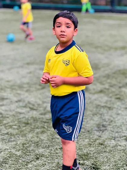 A young player stands confidently on the field. Our training helps build self-assurance in children.