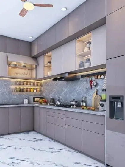 This kitchen uses a subtle two-tone grey palette for a sophisticated feel. The marble-patterned backsplash and integrated refrigerator maintain a seamless and modern aesthetic.