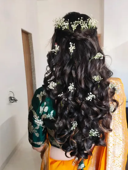 A hairstyle can make all the difference. For this Haldi look, I created soft, open curls and decorated them with delicate baby's breath flowers for a fresh and romantic feel.