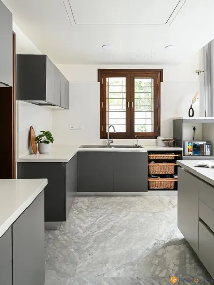 This spacious U-shaped kitchen features dark grey cabinets, a white countertop, and a marble-patterned floor. The large window brings in natural light, and the layout is perfect for someone who loves to cook.