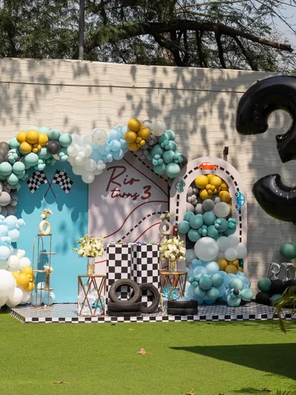 Rio turns 3 with a speedy race car theme! The checkered flags, tire props, and cool blue and yellow balloon decor made this party a winner.