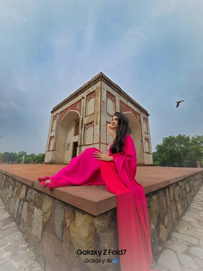 This wide angle shot captures the grandeur of the location and the stunning flow of her bright pink dress. A perfect example of a dramatic, fashion-forward ethnic portrait.