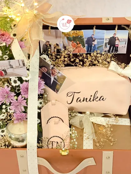 Inside the bridal bliss trunk, showing a personalized pouch, custom luggage tag, and a scented candle.