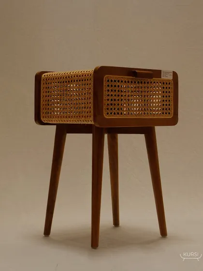 The 'Koshi' bedside table, a piece where luxury is redefined. The combination of a solid teak body and delicate rattan shutters is crafted to perfection.