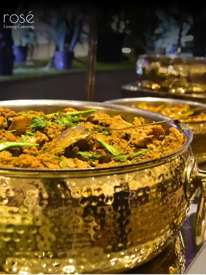 A row of our signature gold-tone chafing dishes, holding a variety of Indian main courses. We ensure our buffet is not only delicious but also a visually stunning centerpiece.