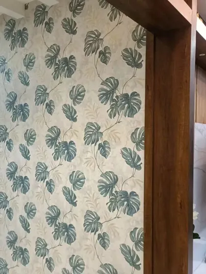 Another view of the popular monstera leaf wallpaper, this time in a hallway. The pattern adds a consistent and stylish theme throughout the home.