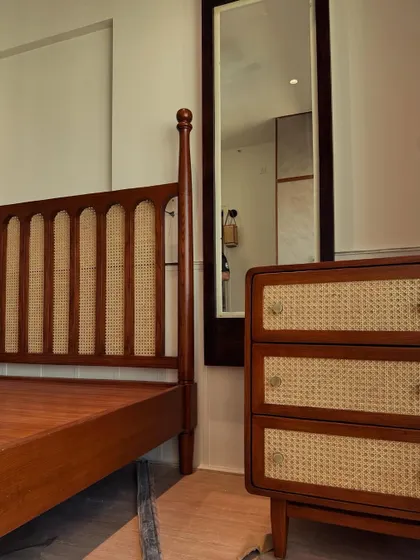 Vintage charm, zero squeaks guaranteed. A detail shot of a custom-made bed with a cane and wood headboard, showcasing classic joinery.