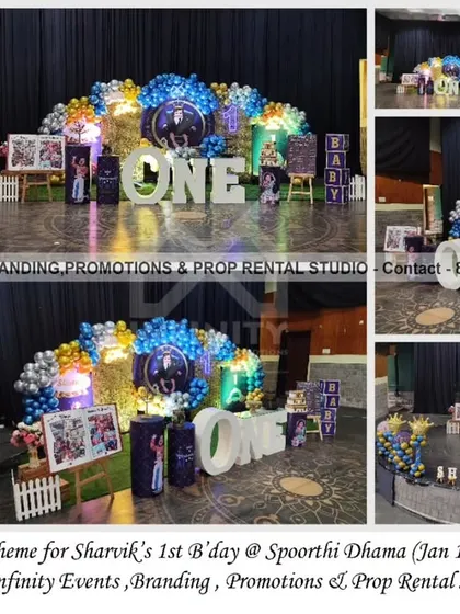 A closer look at the Royal Prince theme for a first birthday at Spoorthi Dhama. This setup features a full stage decoration with a large balloon garland, a "ONE" table, themed cylinder props, and a custom milestone chart, ensuring every detail is fit for a prince.