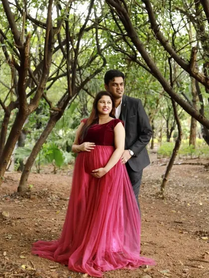 A simple and sweet couple's maternity photo in a forest setting. The client is wearing a beautiful maroon velvet and tulle gown that complements the natural surroundings.