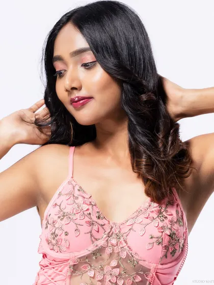 A close-up of the embroidered top of the pink dress.