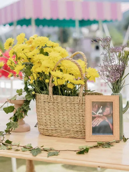 A framed photo of the couple sits in a basket of yellow flowers.