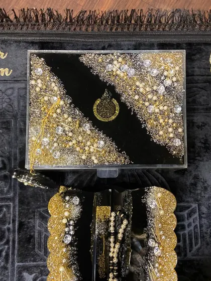 The black and gold gift set displayed on a personalized prayer mat, ready to be gifted.