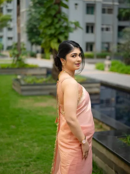 A candid-style walking shot from the same series. The movement in the saree and her backward glance create a dynamic and engaging portrait.