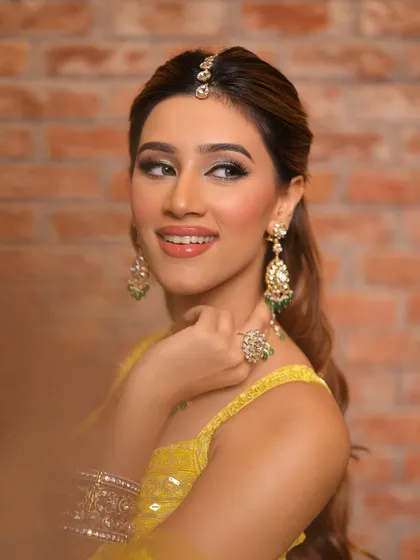 A bright and festive look perfect for a Haldi or Sangeet ceremony. The silver-toned smokey eye is paired with a vibrant yellow outfit and emerald jewellery.