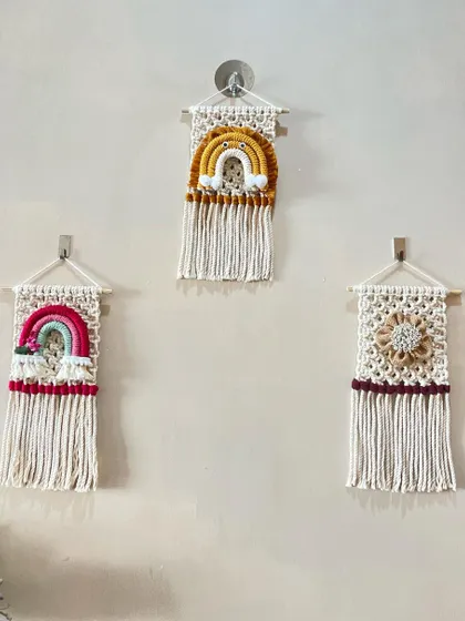 Another view of the three-piece wall hanging set. The combination of rainbows and a floral design creates a cohesive and charming display for a child's room or nursery.