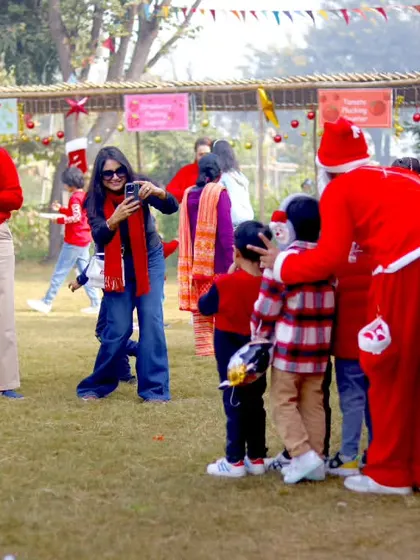 Santa Claus mingling with families at our Christmas event, with children gathering around him for photos.