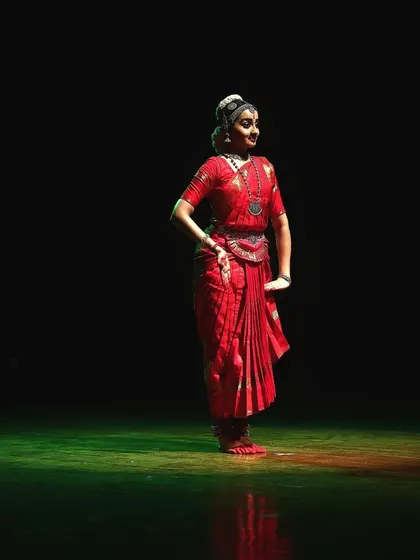 A static pose captured mid-performance, showing the stillness and control required even in moments of rest. The lighting creates a beautiful ambiance.