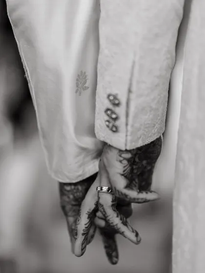 A close-up of their hands, adorned with mehendi, symbolizing their union. It’s a small detail that holds immense meaning, capturing the blend of tradition and personal love story.