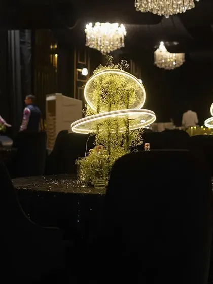 A table setting that is deep, classy, and royal. The glowing centerpiece with its neon rings, the sequined tablecloth, and the overhead chandeliers created an experience in itself.