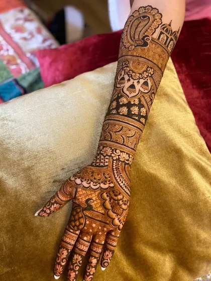A single arm view of a bridal design, showcasing the intricate details. You can see a large paisley motif, architectural elements, and delicate bands creating a layered look.