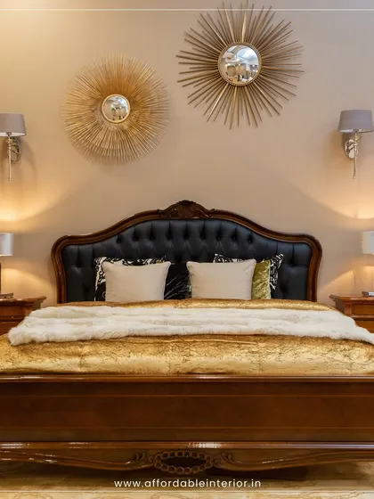 A classic bedroom design featuring a carved wooden bed with a leather headboard, ornate sunburst mirrors, and traditional bedside lamps for a touch of old-world royalty.