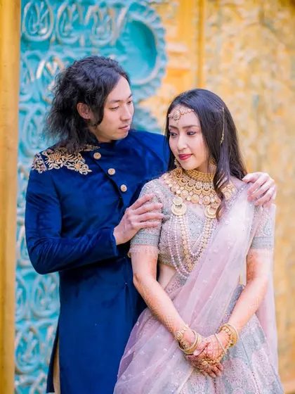 A candid moment of adjustment and care, beautifully captured against a vibrant blue and gold wall. These are the real, unscripted moments I love to photograph.