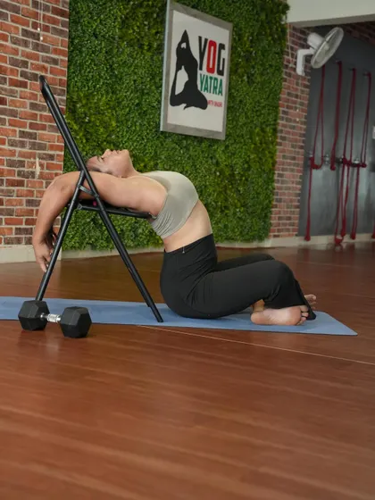 Using a chair for a deep backbend in Vajrasana, a great way to open the thoracic spine.