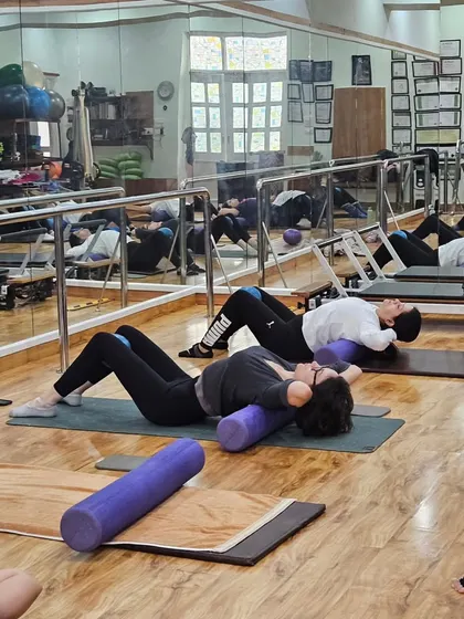 A group session focusing on core and back work using foam rollers and mini stability balls. These props help us engage the deep abdominal muscles that are essential for supporting the spine.