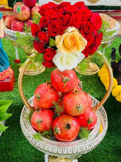 A beautiful fruit arrangement in a silver basket, featuring fresh pomegranates and roses. I believe in making even the simplest offerings look artistic and beautiful.