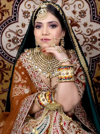 Create a royal Marwari bridal look with our extensive collection. This features a heavily layered jewellery set with a large statement necklace, paired with a multi-colored embroidered lehenga.