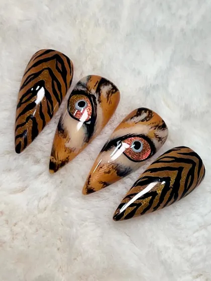 Bring me your boldest ideas. I hand-painted this realistic tiger's eye and stripes, using fine brushes and layering colors to create depth and a striking, lifelike effect on stiletto nail tips.
