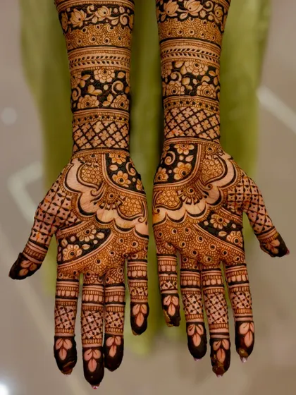 A classic bridal design with a mix of floral and geometric patterns, showing a rich, dark application.