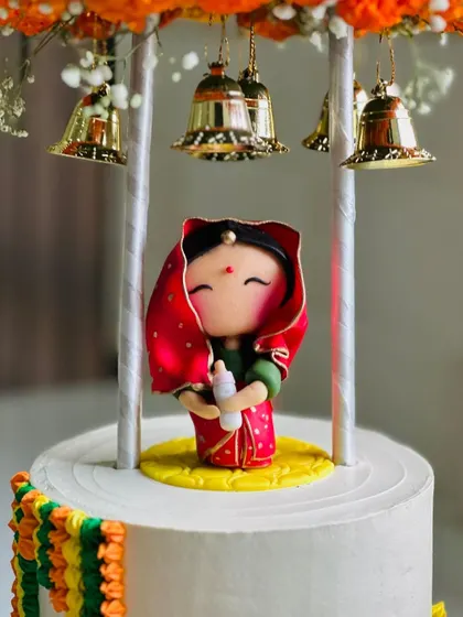 A detailed shot of the adorable, handcrafted baby figurine in a red saree.