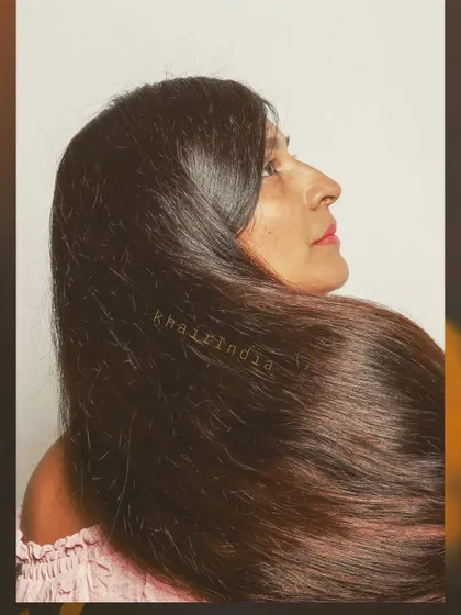 A stunning profile shot showcasing the volume and healthy shine of one of our full silk base wigs. The length and texture look completely natural, providing a truly transformative experience.