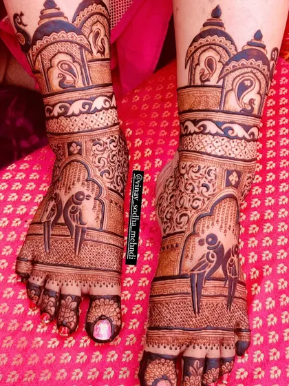 A beautiful bridal foot design with parrots perched inside arched windows. The top of the feet are adorned with architectural domes, creating a complete story.