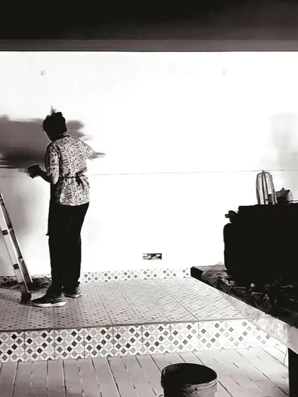 A behind-the-scenes, black and white photo from the diner project, showing the initial stages of sketching and painting on the wall.