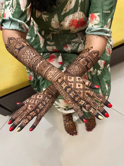 A full view of a bride's hands and feet, showcasing a cohesive design with geometric and floral patterns.