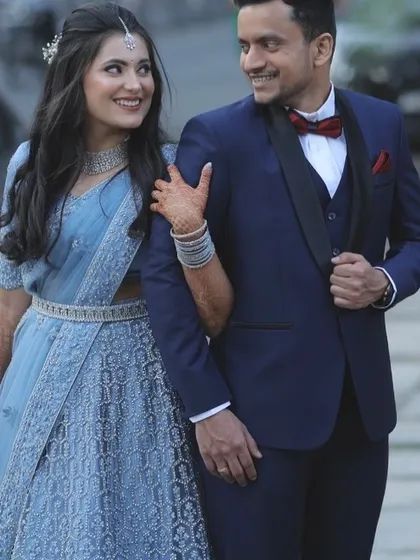 A beautiful couple portrait from their reception. The bride wears a stunning powder blue lehenga saree with diamond jewellery. Her makeup is soft and elegant, with a focus on radiant skin and defined eyes, perfect for the evening's festivities.