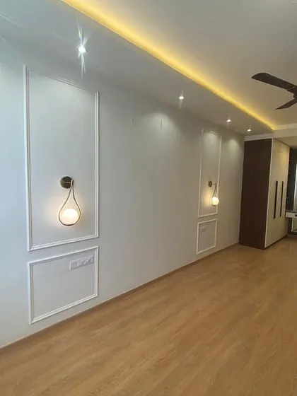 The elegant wall paneling and lighting in this bedroom create a hotel-like sense of luxury and comfort.