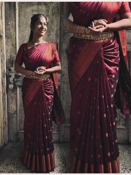 A simple yet elegant South Indian drape on a beautiful maroon silk saree. The pleats are neatly tucked and the pallu is arranged to fall gracefully over the shoulder.