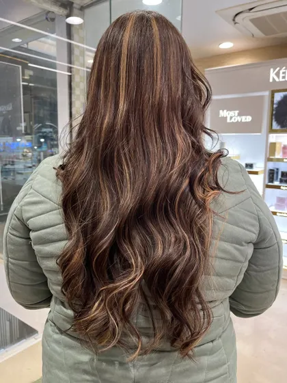 A stunning mane makeover. The long hair is brought to life with beautiful highlights and soft, flowing waves.